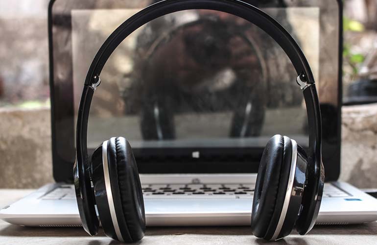 Headphone in front of a laptop -Headphone in front of a laptop - Best sites to download free movie sound tracks