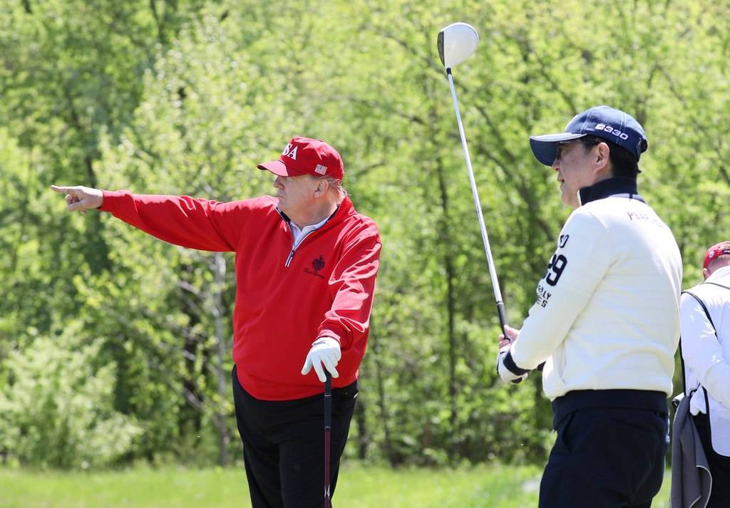 Shinzo Abe and Donald Trump playing golf